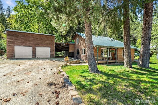 view of front of house featuring a front yard, a porch, dirt driveway, and metal roof