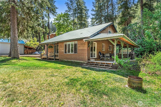 back of house featuring a yard, a shed, and an outbuilding