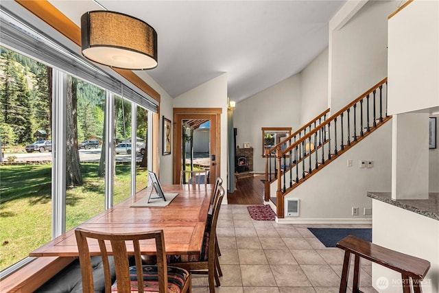 dining room featuring vaulted ceiling, stairs, light tile patterned flooring, and baseboards