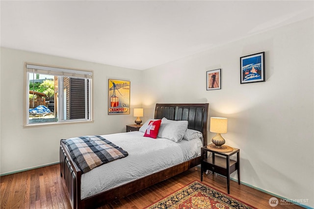 bedroom with wood finished floors and baseboards