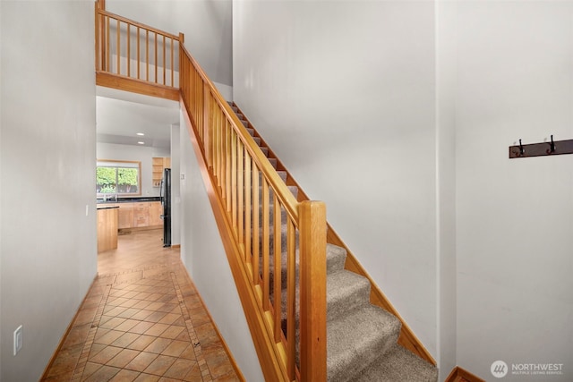 stairway with baseboards, tile patterned floors, and recessed lighting