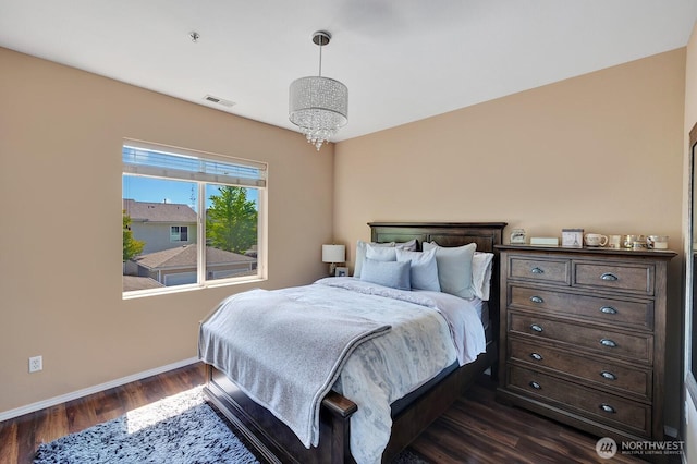 bedroom with baseboards, a chandelier, dark wood-style floors, and visible vents