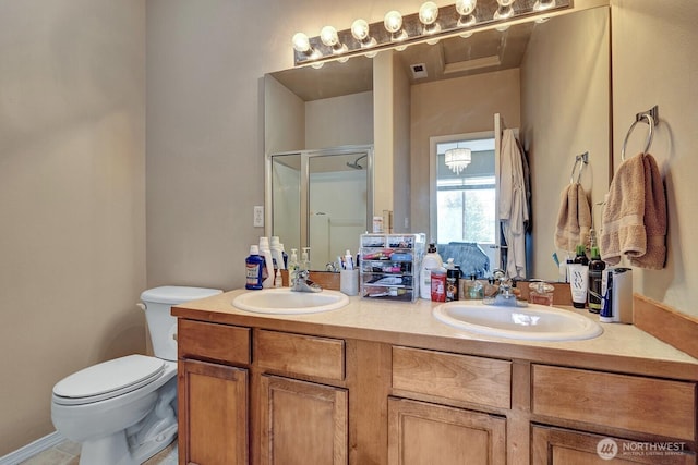full bath featuring double vanity, toilet, a sink, and a stall shower