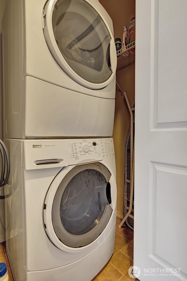 laundry area with laundry area, stacked washer and clothes dryer, and tile patterned flooring