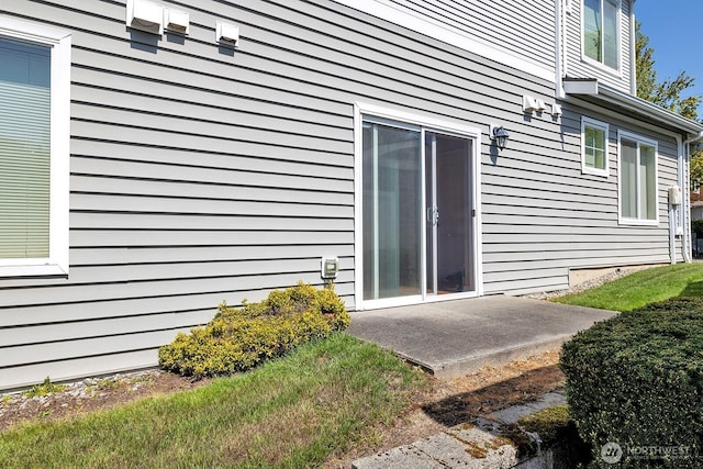 view of exterior entry with a patio
