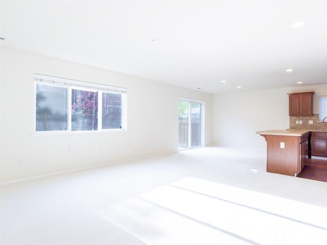 unfurnished living room with baseboards, recessed lighting, and carpet floors
