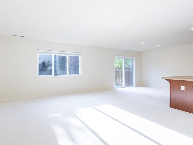 empty room featuring baseboards, visible vents, recessed lighting, and light colored carpet