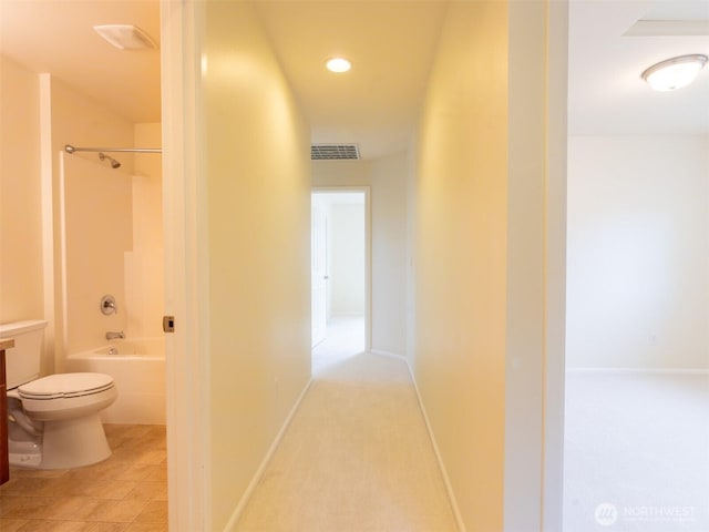hall featuring baseboards and visible vents