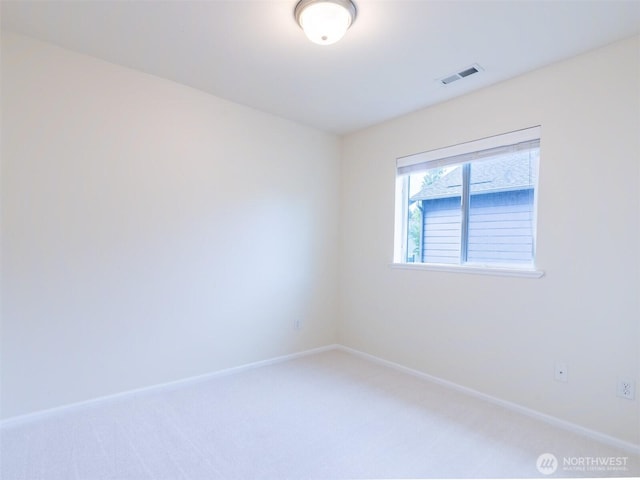 empty room featuring baseboards, visible vents, and light carpet