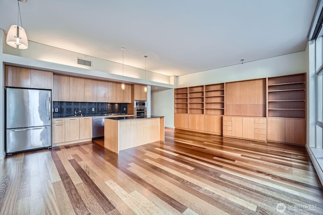 909 5th Ave Unit 701, Seattle, WA 98104 - kitchen with light wood finished floors, dark countertops, appliances with stainless steel finishes, and modern cabinets