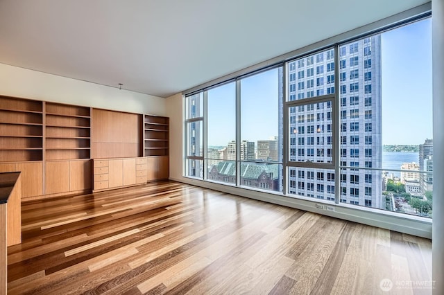 909 5th Ave Unit 701, Seattle, WA 98104 - interior space with a water view, a view of city, floor to ceiling windows, and wood finished floors
