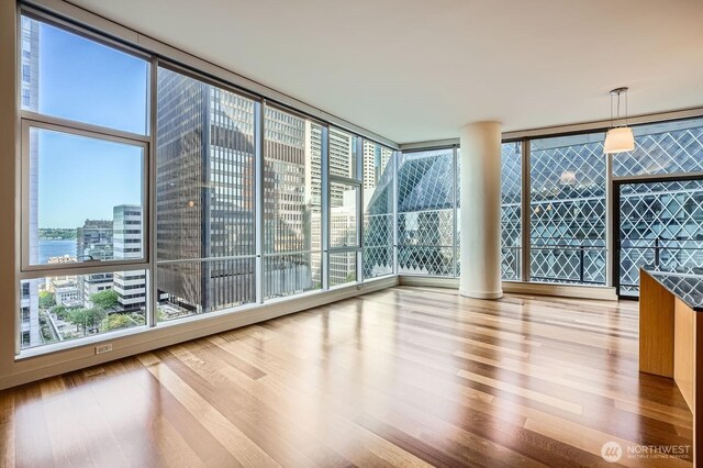 909 5th Ave Unit 701, Seattle, WA 98104 - empty room featuring a wall of windows, a view of city, and wood finished floors