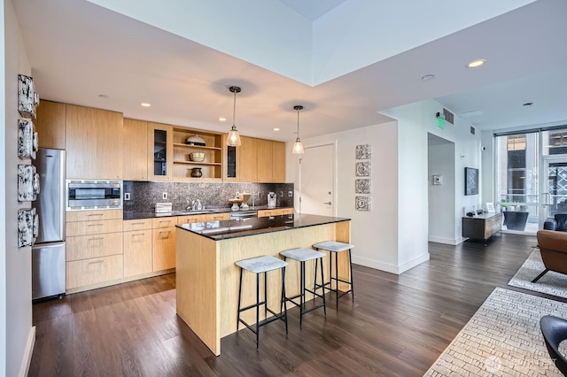 909 5th Ave Unit 701, Seattle, WA 98104 - kitchen featuring a breakfast bar, a sink, a kitchen island, dark countertops, and stainless steel appliances