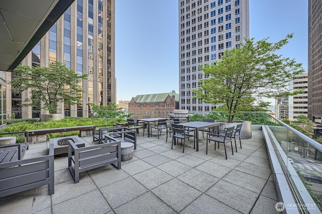 909 5th Ave Unit 701, Seattle, WA 98104 - view of patio with a balcony, outdoor dining space, a city view, and a fire pit