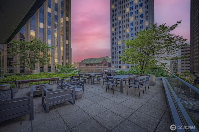 909 5th Ave Unit 701, Seattle, WA 98104 - patio terrace at dusk with an outdoor fire pit and outdoor dining area