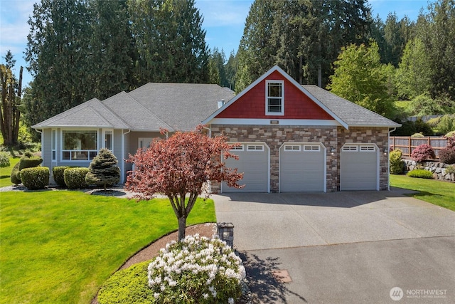 craftsman inspired home with a garage, a front lawn, driveway, and stone siding