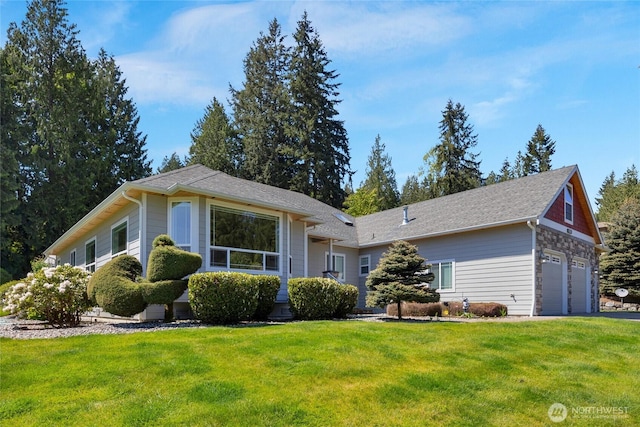 view of front of home featuring a garage, a front yard, and a shingled roof