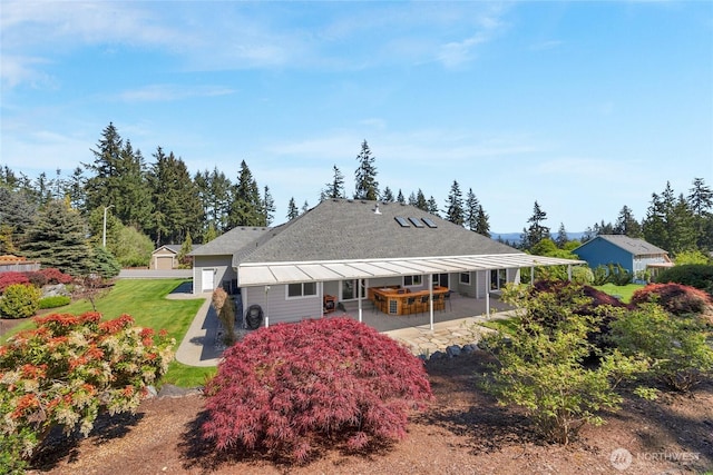 rear view of property with a yard and a patio area