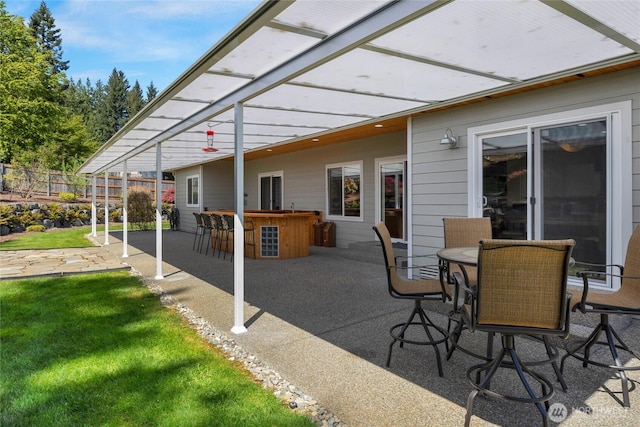 view of patio with fence and outdoor dry bar