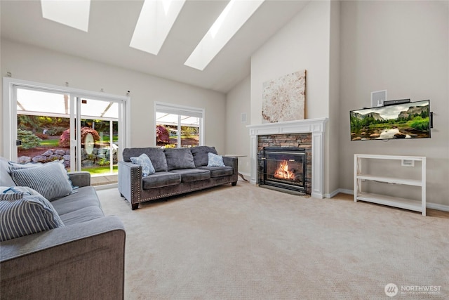 living area with carpet, high vaulted ceiling, a skylight, and a fireplace