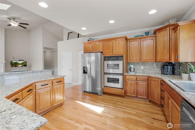 kitchen with light wood-style floors, stainless steel appliances, a ceiling fan, recessed lighting, and decorative backsplash
