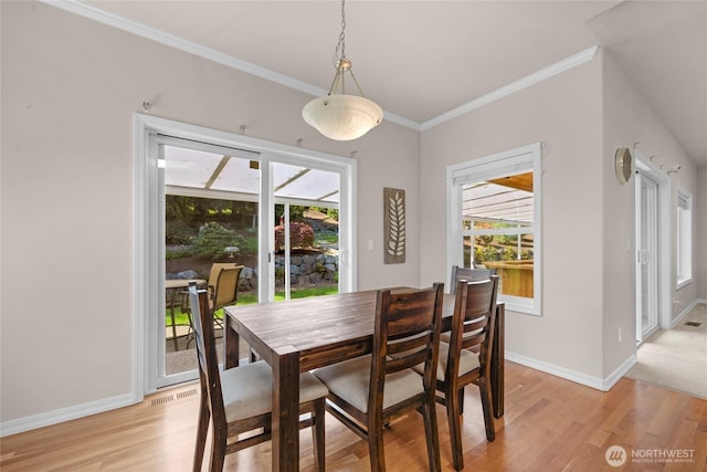 dining space featuring light wood-style floors, baseboards, crown molding, and a healthy amount of sunlight