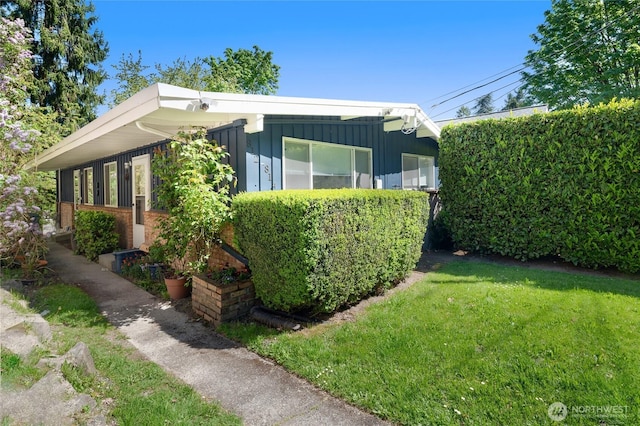 812 N 59th St, Seattle, WA 98103 - view of property exterior featuring a lawn and board and batten siding