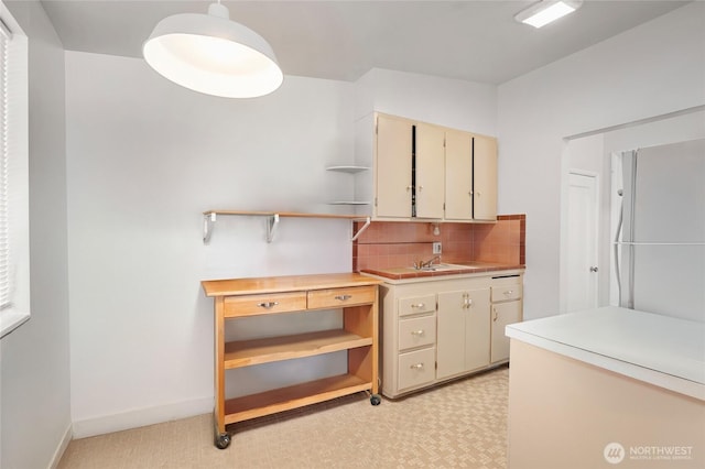 812 N 59th St, Seattle, WA 98103 - kitchen with open shelves, light floors, cream cabinetry, light countertops, and tasteful backsplash