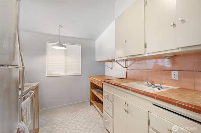 812 N 59th St, Seattle, WA 98103 - kitchen featuring a sink, light floors, baseboards, tile countertops, and tasteful backsplash