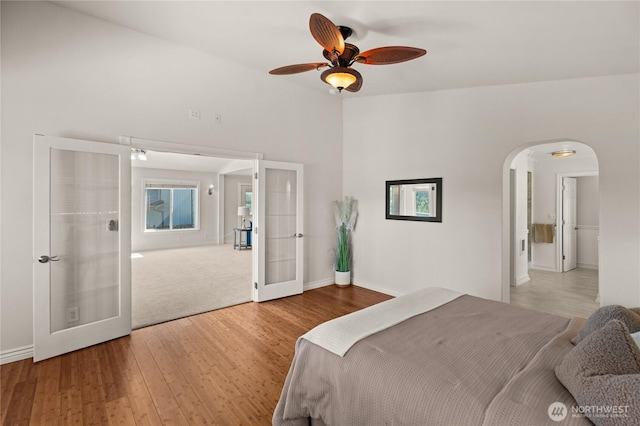 7295 Navajo Trl NE, Bremerton, WA 98311 - bedroom with french doors, arched walkways, wood finished floors, baseboards, and a ceiling fan