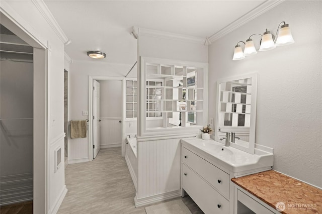 7295 Navajo Trl NE, Bremerton, WA 98311 - bathroom with crown molding, wood finished floors, vanity, and a walk in closet
