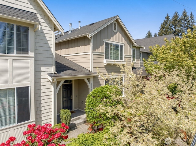 view of front of home featuring board and batten siding and roof with shingles