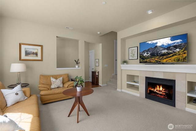 living room featuring a fireplace, carpet flooring, stairs, and baseboards