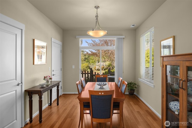 dining area featuring light wood finished floors, plenty of natural light, and baseboards