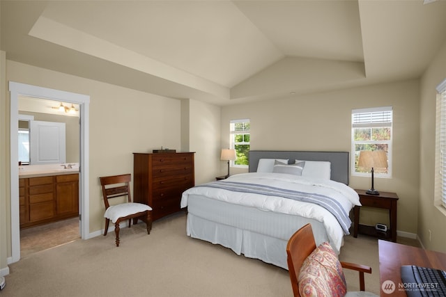 bedroom featuring a sink, light colored carpet, ensuite bath, lofted ceiling, and baseboards