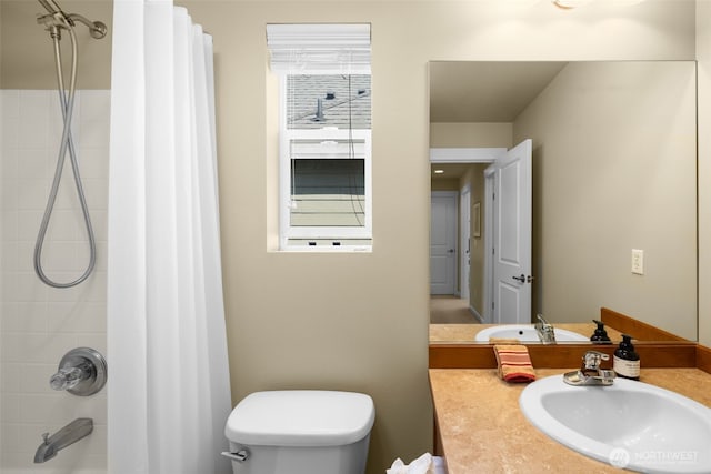 bathroom featuring toilet, shower / bath combo with shower curtain, and vanity