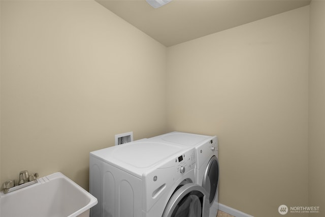 clothes washing area with independent washer and dryer and baseboards