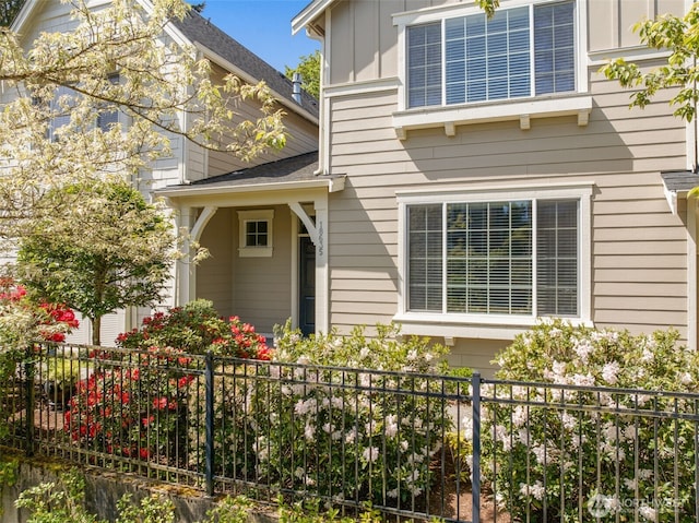 view of side of home with fence and board and batten siding