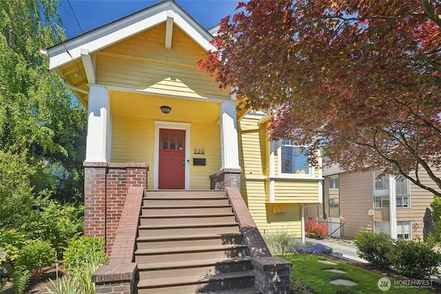 shotgun-style home with brick siding and stairs