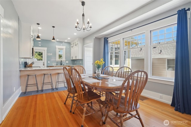 dining room featuring a chandelier, baseboards, light wood-style floors, healthy amount of natural light, and recessed lighting