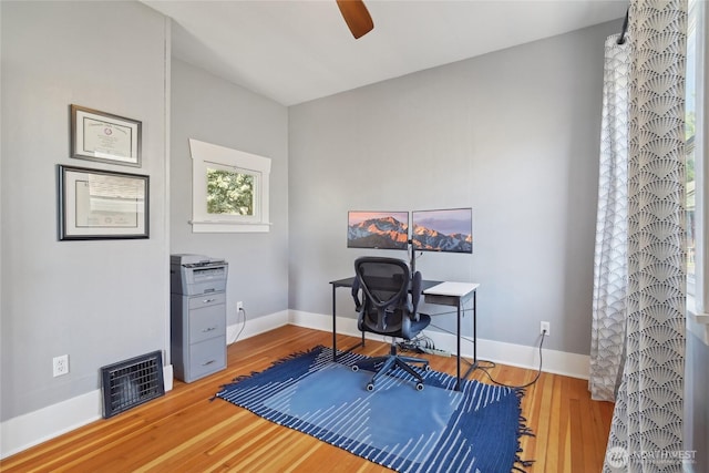 office featuring a ceiling fan, wood finished floors, and baseboards