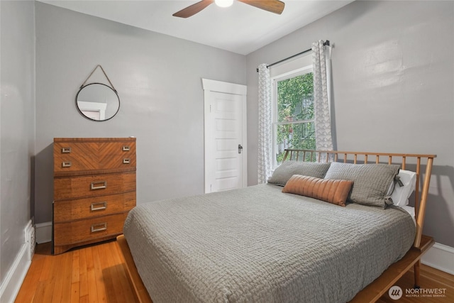 bedroom featuring light wood-type flooring, baseboards, and a ceiling fan