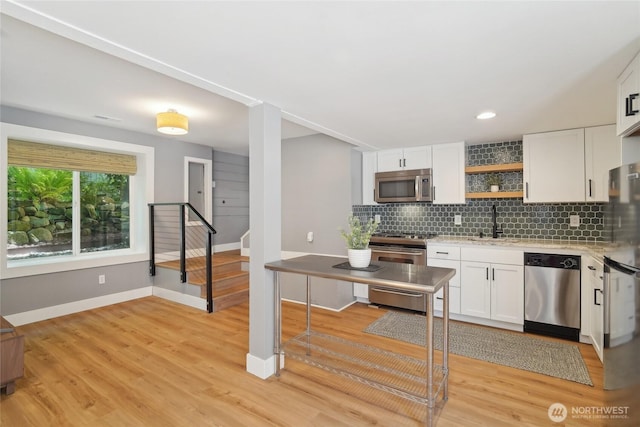 kitchen with stainless steel appliances, open shelves, backsplash, white cabinetry, and recessed lighting