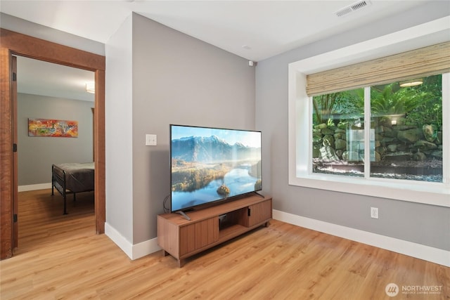 living area with light wood-style flooring and baseboards