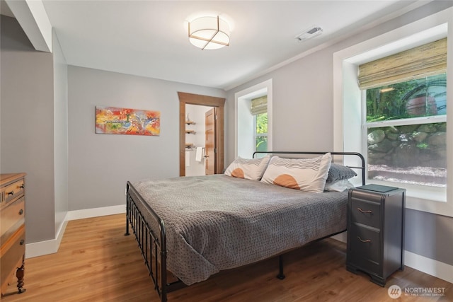 bedroom featuring light wood finished floors and baseboards