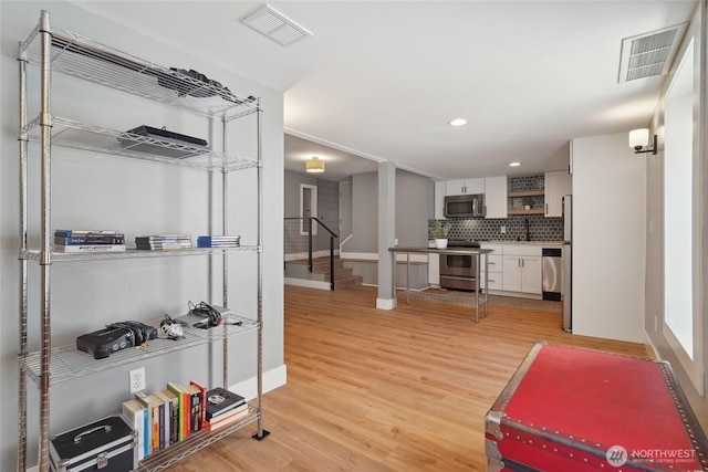 interior space with light wood-style floors, baseboards, and recessed lighting