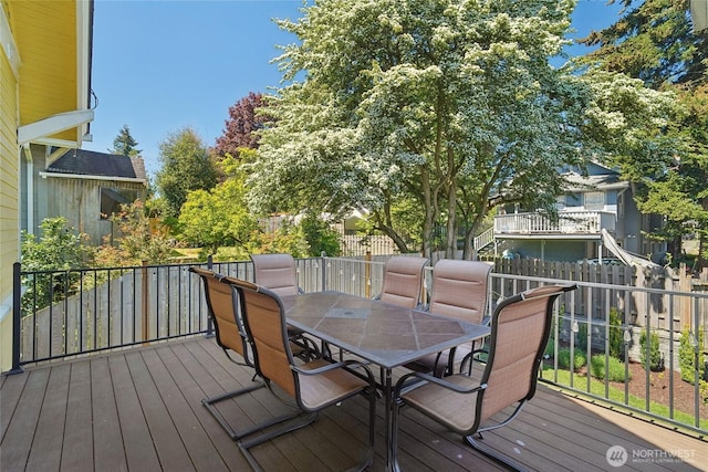 deck featuring outdoor dining area and a fenced backyard