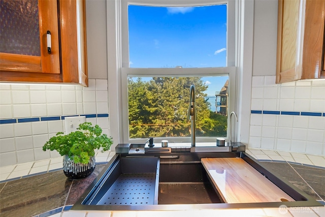 room details featuring a sink, tasteful backsplash, and brown cabinets
