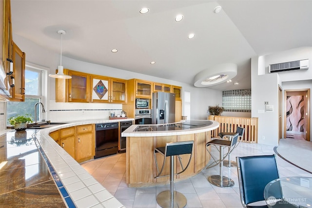 kitchen featuring a sink, tile counters, recessed lighting, a kitchen island, and black appliances