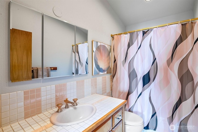 bathroom with vanity, curtained shower, toilet, and tasteful backsplash